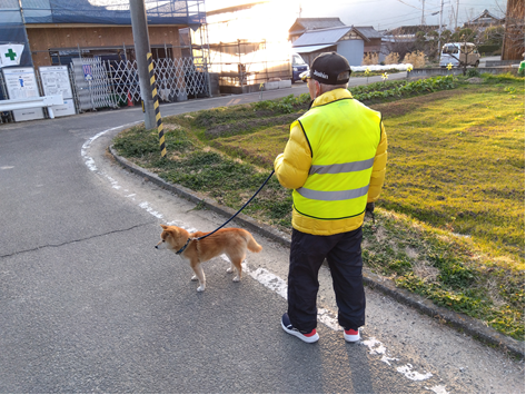 上村様が柴犬と一緒に散歩している後ろ姿。靴にはあしらせが装着してある。